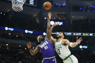 Boston Celtics' Jayson Tatum (0) shoots against Milwaukee Bucks' Jrue Holiday during the first half of an NBA basketball game Thursday, March 30, 2023, in Milwaukee. (AP Photo/Aaron Gash)