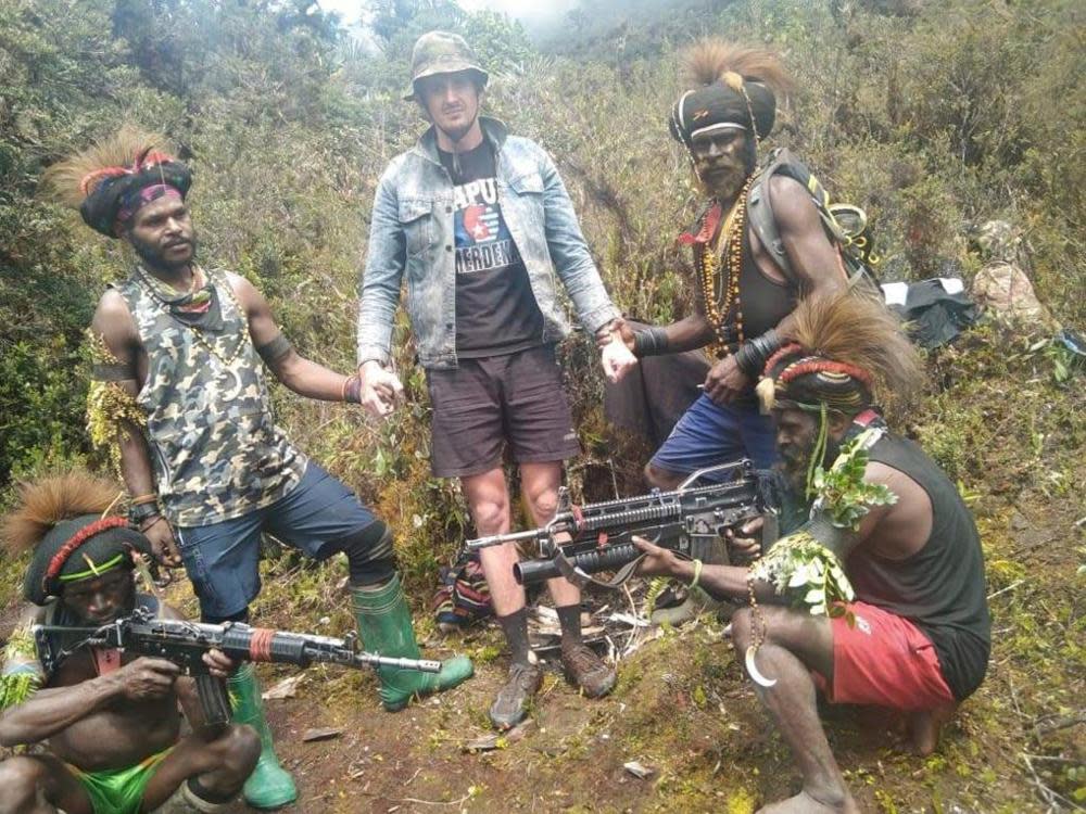 In this undated photo released by West Papua Liberation Army, Papuan separatist rebels pose with New Zealander Phillip Mehrtens, at an undisclosed location.