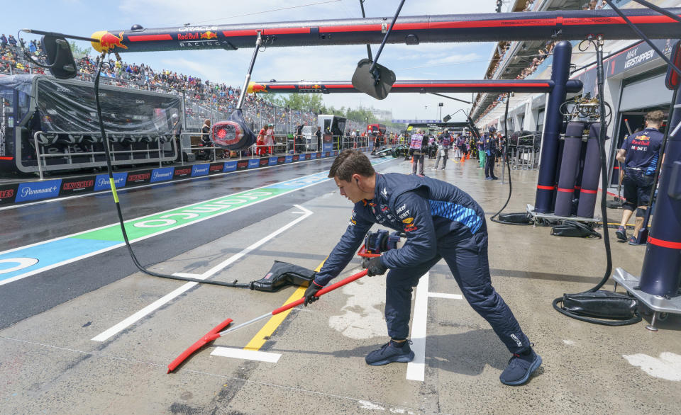 A member of the Red Bull Racing crew clears water from the pit lane following a heavy downpour during practice for the Formula 1 Canadian Grand Prix auto race Friday, June 7, 2024, in Montreal. (Paul Chiasson/The Canadian Press via AP)