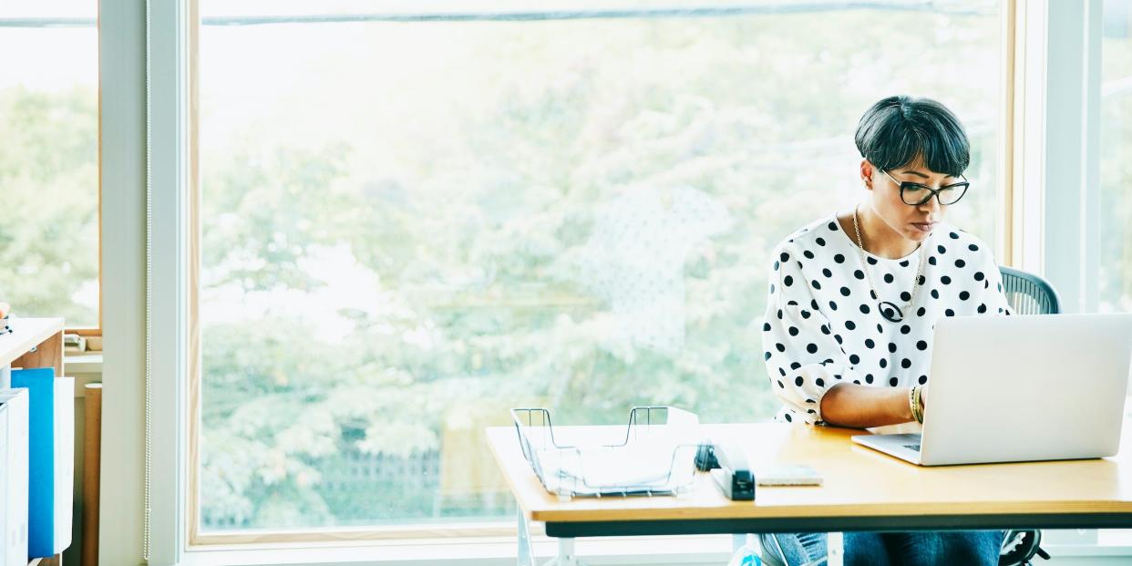 businesswoman sitting at desk using laptop computer