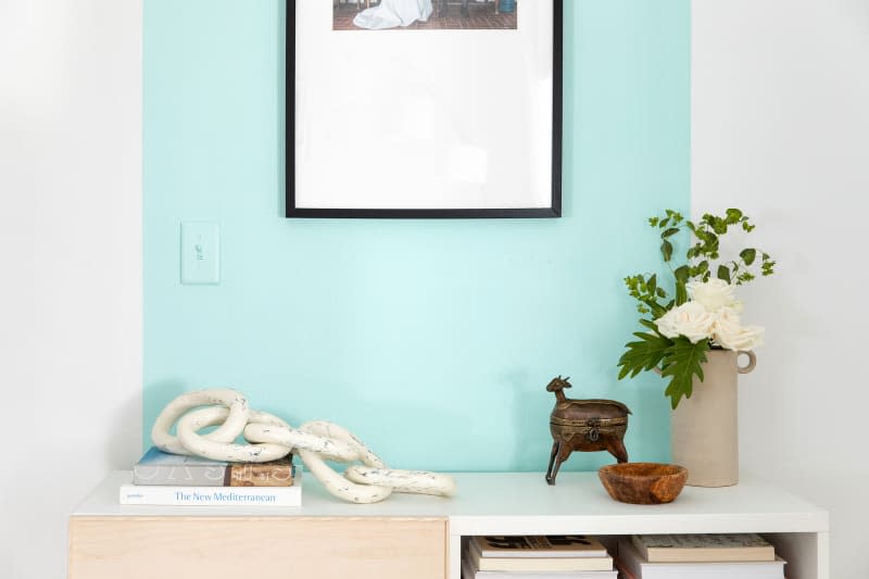 entry wall painted with accent strip of turquoise paint, with light switch painted to match