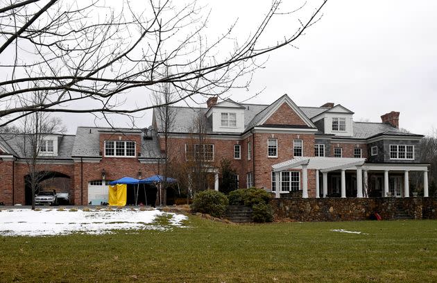 A yellow tarp is set up and watched over by a police officer outside of the garage to Fotis Dulos' home on Jan. 28, 2020, in Farmington, Connecticut.