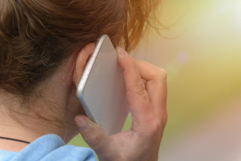 A woman is pictured talking on a phone.