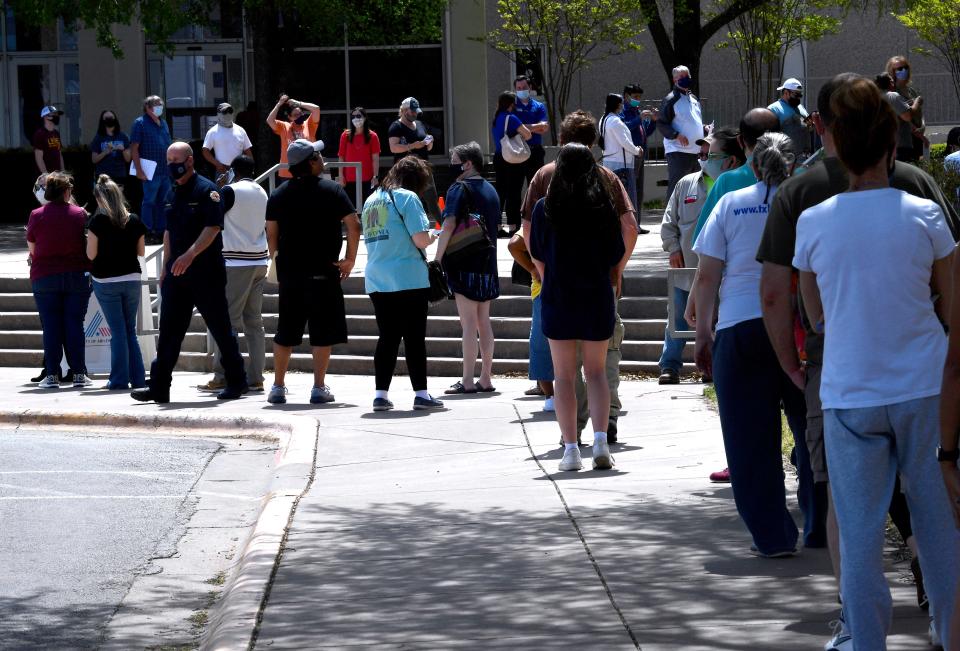 People wait in line for a COVID-19 vaccine at the Abilene Convention Center.