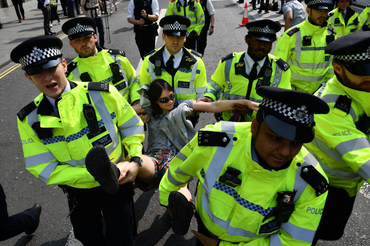 Police carry away a climate change activist blockading Oxford Circus during an environmental protest by the Extinction Rebellion group. (GETTY)