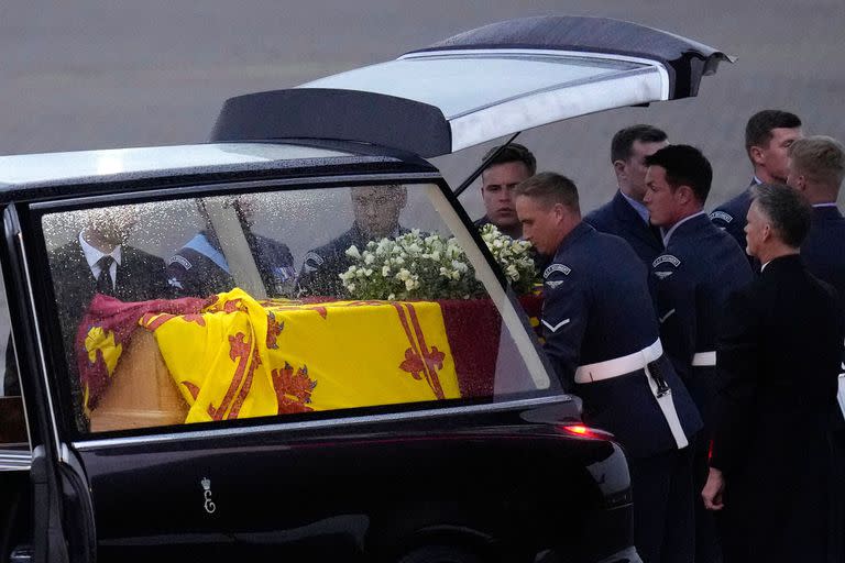 Los portadores del féretro del Queen's Color Squadron (63 Squadron RAF Regiment) colocan el ataúd de la reina Isabel II en el Royal Hearse después de haberlo retirado del C-17 en la base aérea de la Royal Air Force Northolt el 13 de septiembre de 2022