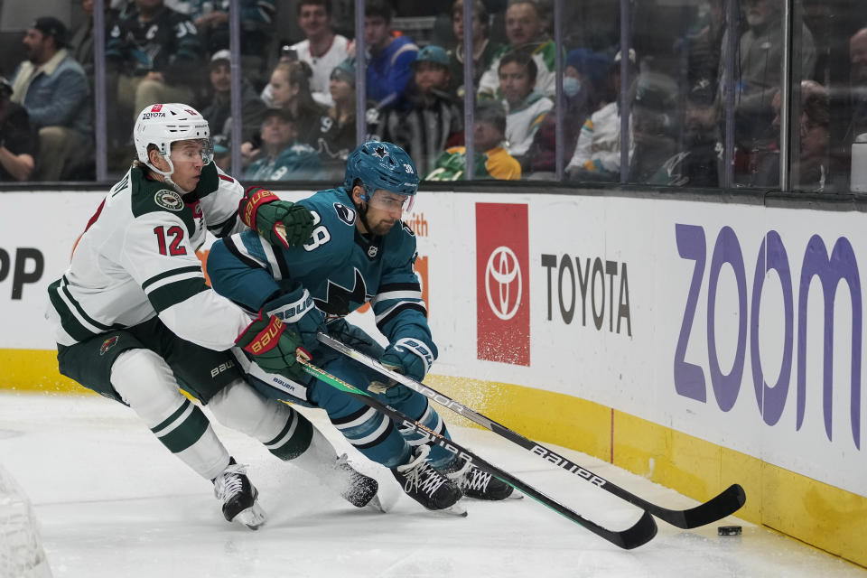 Minnesota Wild left wing Matt Boldy, left, and San Jose Sharks defenseman Mario Ferraro compete for possession of the puck during the first period of an NHL hockey game in San Jose, Calif., Thursday, Dec. 22, 2022. (AP Photo/Godofredo A. Vásquez)