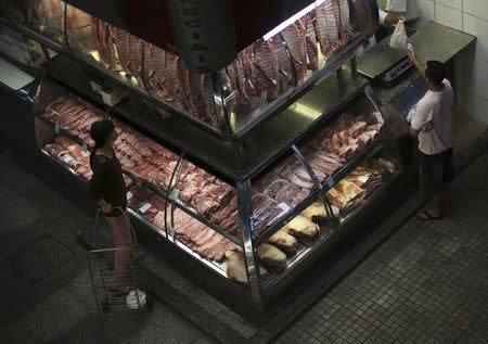 A customer (R) pays for his meat at the Municipal Market in Sao Paulo October 10, 2014. REUTERS/Nacho Doce