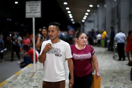 Arnovis Guido and his ex-wife Mirna Portillo wait for their daughter Maybelline Guido at the Mons. Oscar Arnulfo Romero International Airport in San Luis Talpa, El Salvador, June 28, 2018. REUTERS/Jose Cabezas