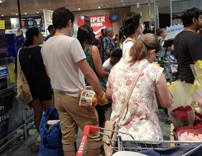 Customers are seen lining up next to each other in Aldi.