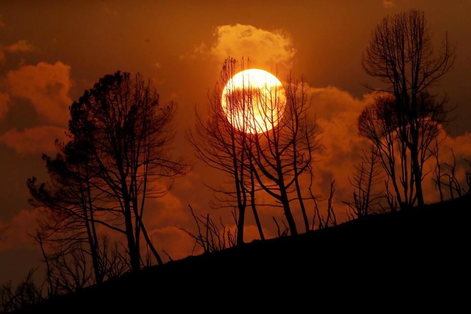 El sol se pone detrás de una cresta carbonizada por el incendio de Roble cerca de Mariposa el martes.