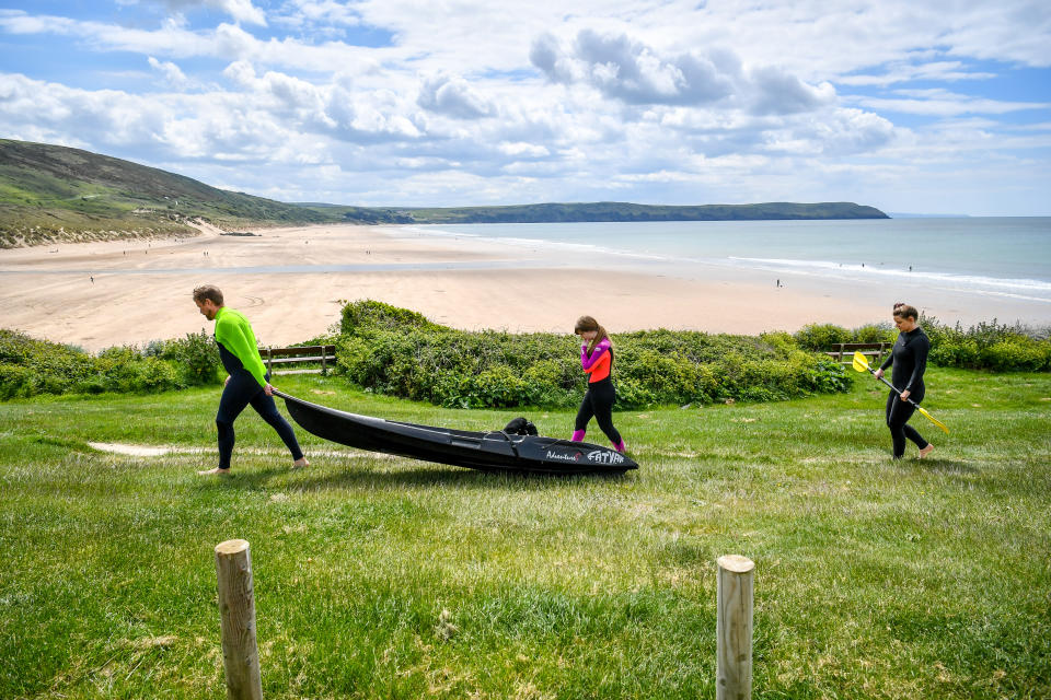 Kyakers wear wetsuits as they make their way towards the beach in Woolacombe, Devon.