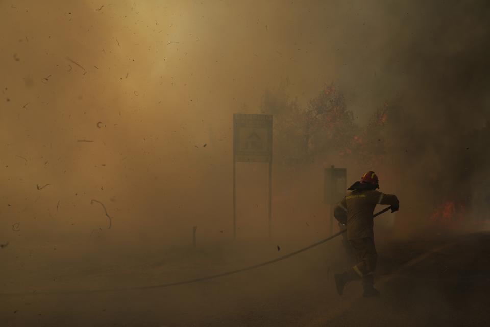 FILE - A firefighter tries to extinguish the flames during a wildfire near Megara town, west of Athens, Greece, July 20, 2022. Major wildfires in Europe are starting earlier in the year, becoming more frequent, doing more damage and getting harder to stop. And, scientists say, they’re probably going to get worse as climate change intensifies unless countermeasures are taken. (AP Photo/Petros Giannakouris, File)