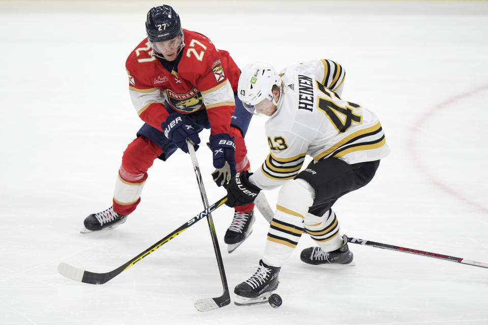 Boston Bruins center Danton Heinen (43) and Florida Panthers center Eetu Luostarinen (27) battle for the puck during the second period of Game 5 of the second-round series of the Stanley Cup Playoffs, Tuesday, May 14, 2024, in Sunrise, Fla. (AP Photo/Wilfredo Lee)