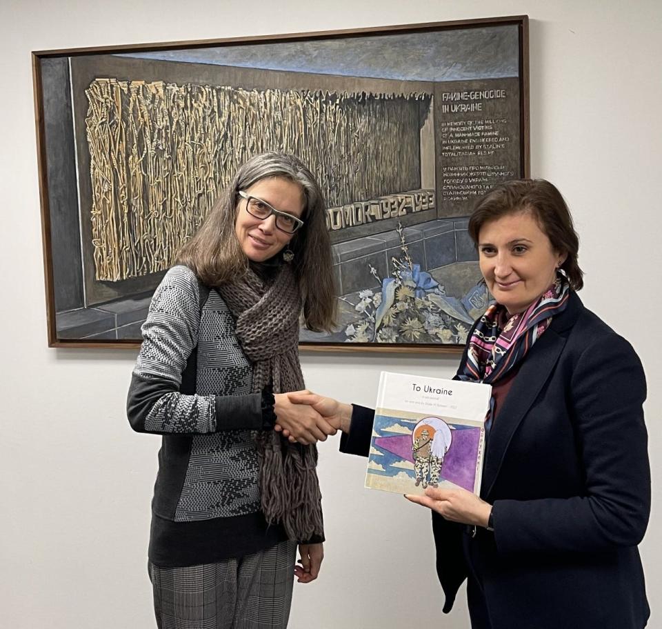 Elodie Richard, New Smyrna Beach artist, presents a copy of her artbook project to Ukraine Embassy First Secretary Kateryna Smagliy in Washington, D.C., Dec. 19, 2022.