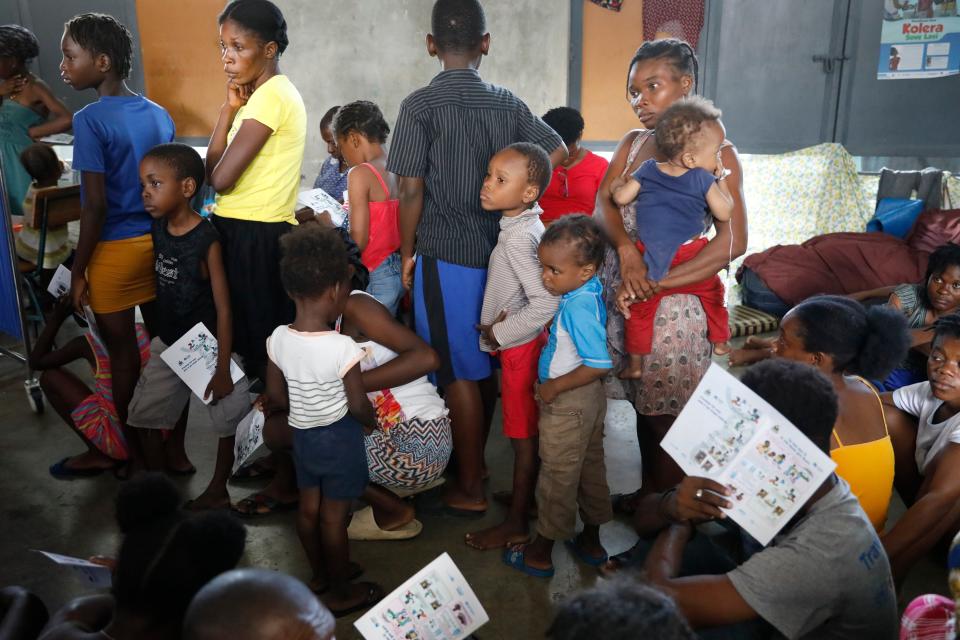 Residents who were displaced from their homes due to clashes between police and gang members, stand in line as they wait to be examined at a mobile medical clinic at a public school serving as a shelter in Port-au-Prince, Haiti, Friday, March 8, 2024. (AP Photo/Odelyn Joseph)