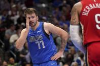 Dallas Mavericks guard Luka Doncic (77) looks toward an official standing nearby after being fouled by New Orleans Pelicans' Willy Hernangomez, right, while shooting in the second half of an NBA basketball game in Dallas, Friday, Dec. 3, 2021. (AP Photo/Tony Gutierrez)