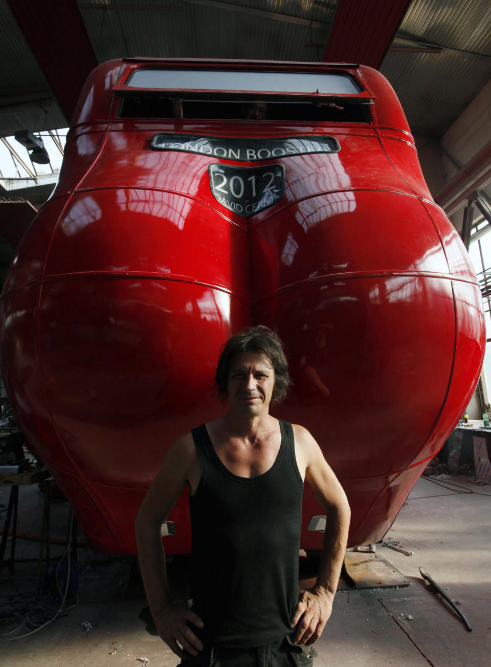 Czech artist David Cerny poses next to a London bus that he has transformed into a robotic sculpture in Prague