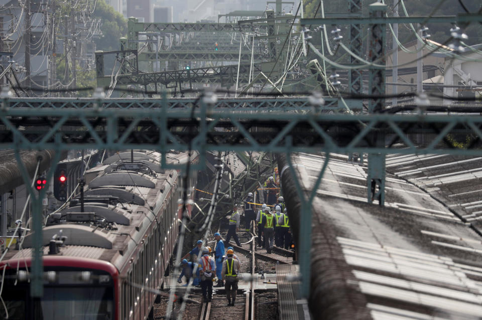 Rescue officers, police and railway company employees work at the scene where a train derailed during a collision with a truck in Yokohama, near Tokyo, Japan September 5, 2019. REUTERS/Issei Kato