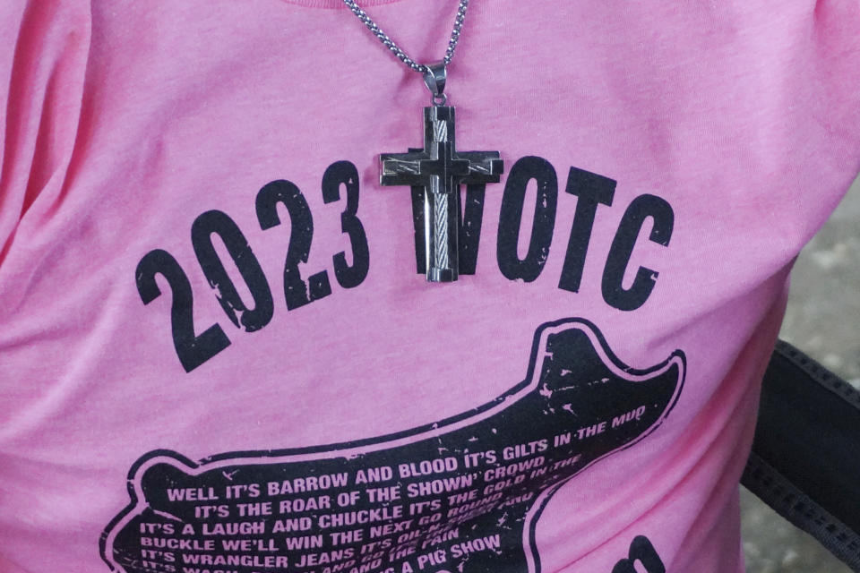 Kolby "Jack Cheese" Peters, a 17-year-old Lutheran from Minnesota's West Otter Tail County, wears a cross over his T-shirt in the swine barn where he shows his crossbred Hampshire hog during the Minnesota State Fair in Falcon Heights, Minn., on Thursday, Aug. 24, 2023. (AP Photo/Giovanna Dell'Orto)