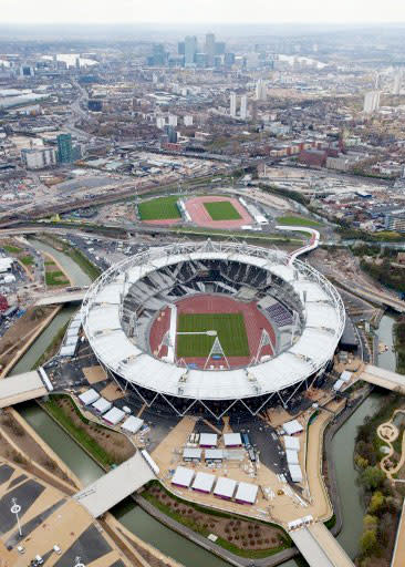 An aerial view of the Olympic Park in London showing the Olympic Stadium (C), the warm up track and Canary Wharf in the background.  AFP PHOTO / LONDON 2012 / ANTHONY CHARLTON