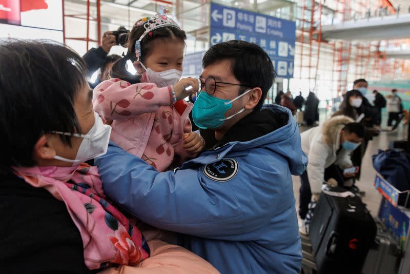 FOTO DE ARCHIVO. Varias personas se abrazan en la puerta de llegadas internacionales del Aeropuerto Internacional de Pekín Capital después de que China levantara el requisito de cuarentena por la enfermedad del coronavirus (COVID-19) para los viajeros entrantes en Pekín, China