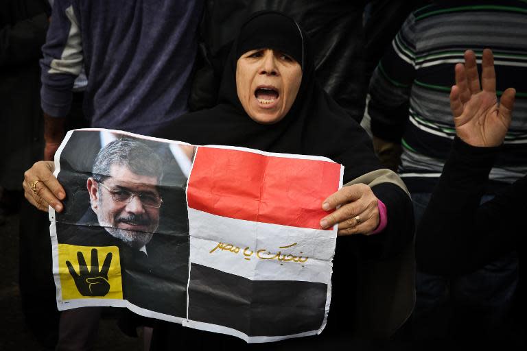 A supporter of the Muslim Brotherhood movement holds a placard showing ousted president Mohamed Morsi during a demonstration on January 24, 2015 in the Cairo district of Heliopolis