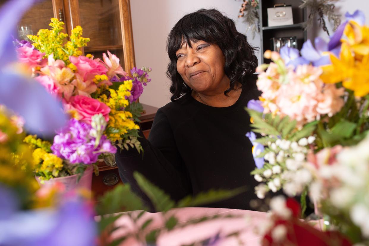 Shirley Wright, owner of Breezy Designs by Shirls, 2828 S.W. Arrowhead Road, smiles through an assortment of floral arrangements prepared for customers.