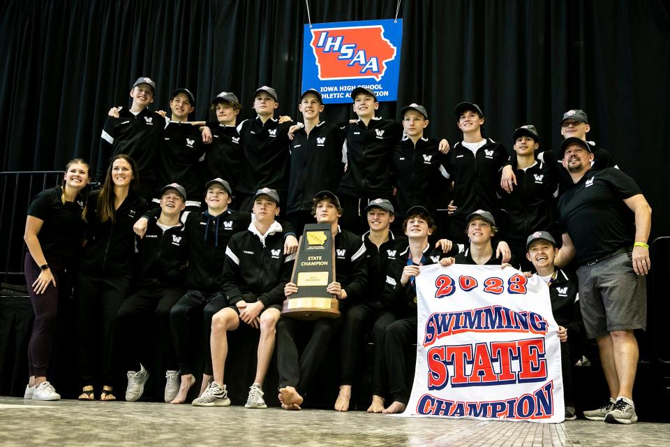 Waukee swimmers pose for a photo with their state championship trophy.