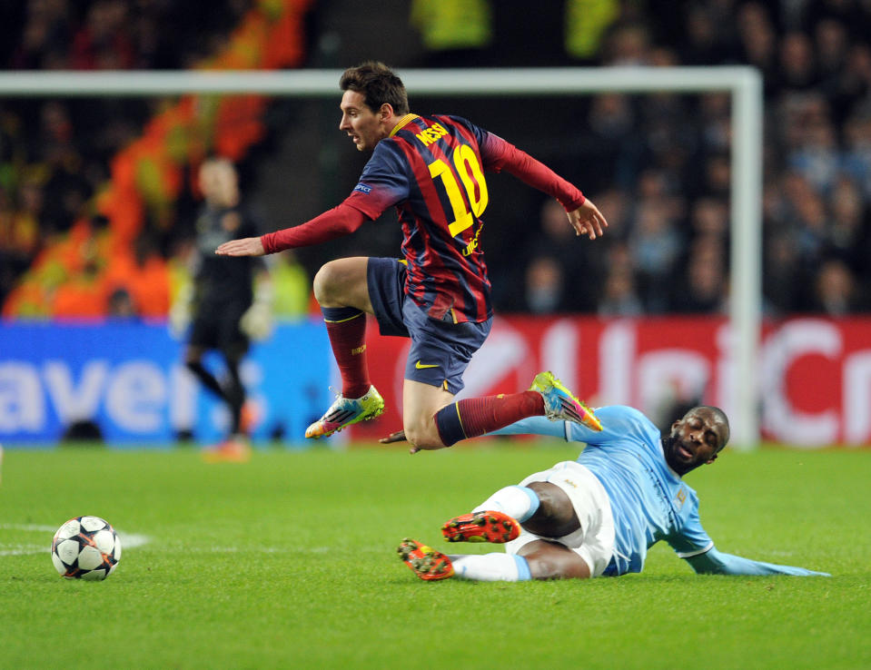 Manchester City's Yaya Toure, right, attempts a tackle Barcelona's Lionel Messi during their Champions League Round of 16 soccer match at the Etihad Stadium in Manchester, England, Tuesday, Feb. 18, 2014. (AP Photo/Clint Hughes)