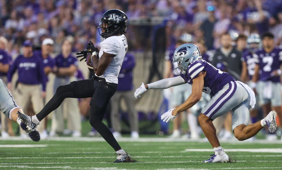 Central Florida defensive back Corey Thornton, left, intercepts a pass in front of Kansas State wide receiver Keagan Johnson during the first half of an NCAA college football game on Saturday, Sept. 23, 2023, in Manhattan, Kan. (AP Photo/Travis Heying)