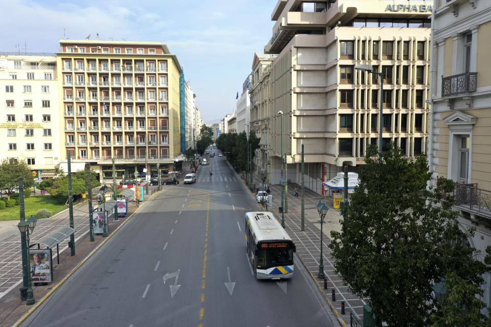In this Wednesday, April 1, 2020 photo, a view of a virtually deserted Stadiou street in Athens. Deserted squares, padlocked parks, empty avenues where cars were once jammed bumper-to-bumper in heavy traffic. The Greek capital, like so many cities across the world, has seen its streets empty as part of a lockdown designed to stem the spread of the new coronavirus. (AP Photo/Thanassis Stavrakis)