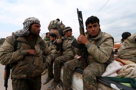 Kurdish People's Protection Units (YPG) fighters carry their weapons while riding on the back of a pick-up truck in Qamishli, Syria, March 11, 2016. REUTERS/Rodi Said