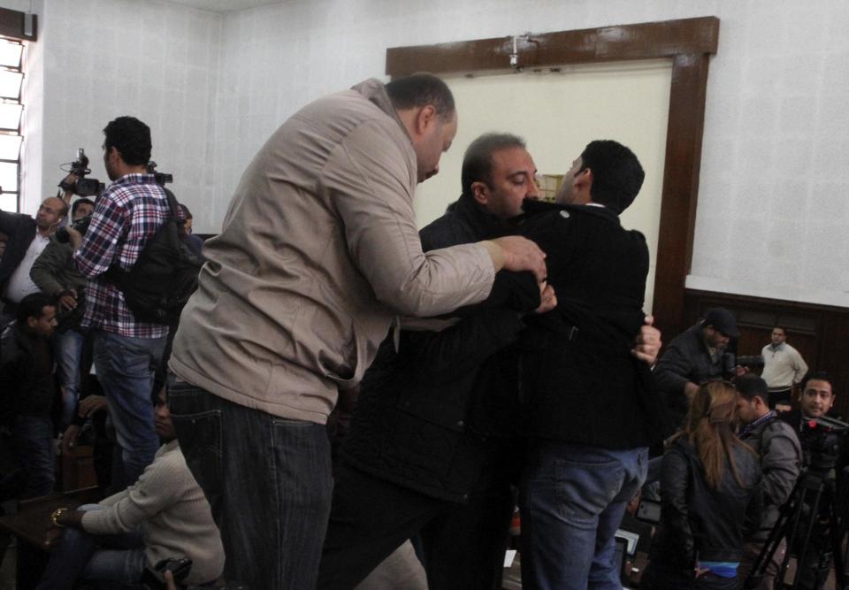 Members of the Muslim Brotherhood clash with policemen during the trial of the Brotherhood leaders in Cairo