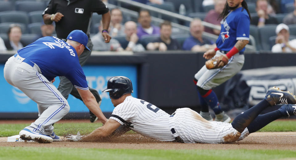 Toronto Blue Jays starting pitcher Clayton Richard, left, tags out New York Yankees' Giancarlo Stanton at third during the first inning of a baseball game Tuesday, June 25, 2019, in New York. Stanton left the game after the third inning. (AP Photo/Kathy Willens)