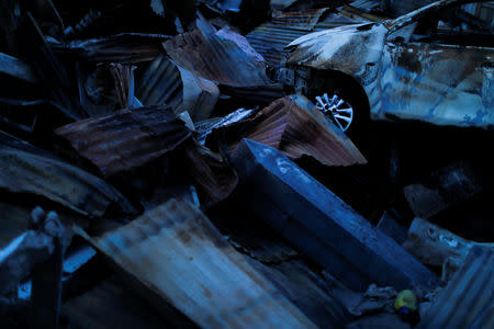 A destroyed car lies among debris in Balaroa neighbourhood hit by an earthquake and ground liquefaction in Palu, Central Sulawesi, Indonesia, October 10, 2018. REUTERS/Jorge Silva
