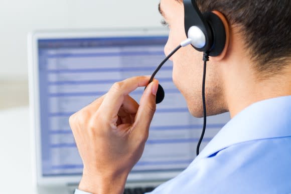 A customer service representative at work in front of a computer.