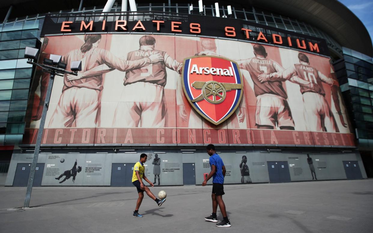 People play football outside the stadium because they are not allowed in - REUTERS