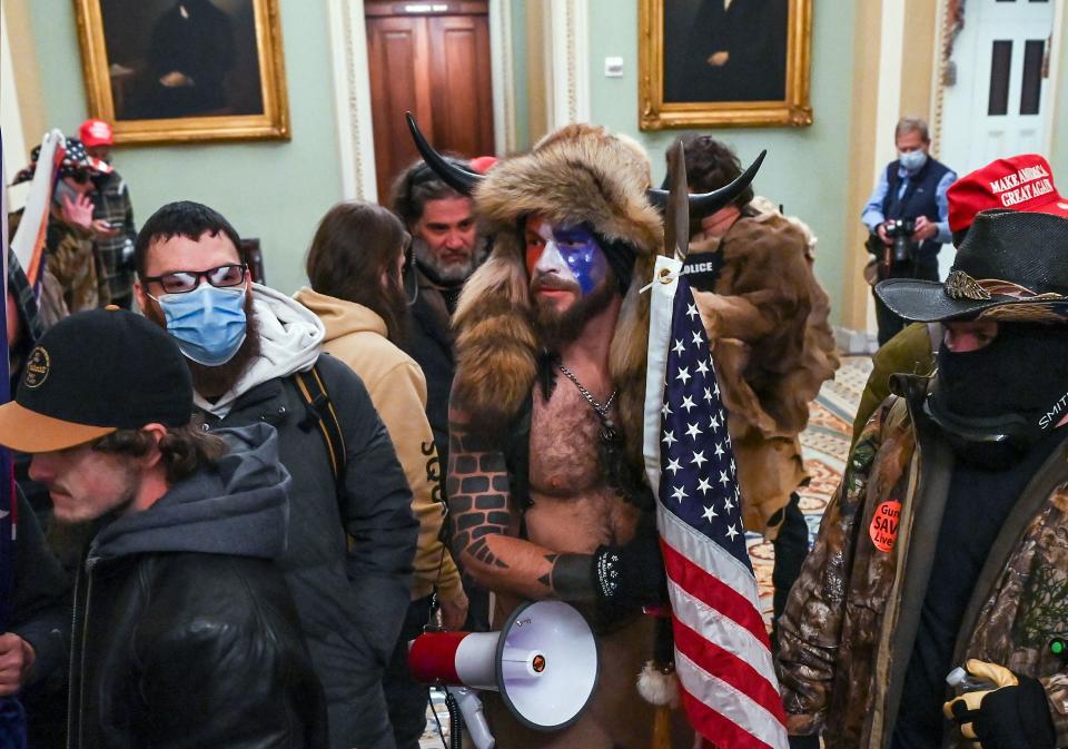 Jacob Anthony Chansley aka Jake Angeli aka the QAnon shaman wears face paint and horns in the Capitol on Jan. 6, 2021. He was later arrested and charged.