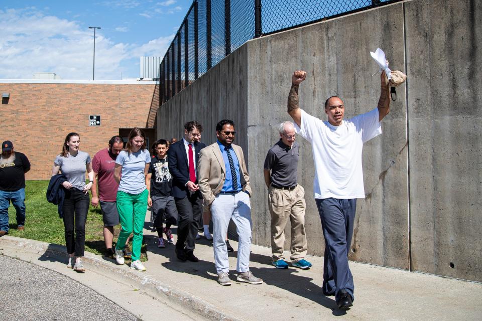 Ronnell Johnson raises his arms outside of the Washtenaw County Jail after being released in Ann Arbor on Wednesday, June 1, 2022.