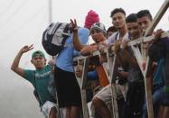 Migrantes abordan un camión en San Pedro Sula, Honduras, miércoles 15 de enero de 2020, con la esperanza de formar una caravana hacia el lejano Estados Unidos. (AP Foto/Delmer Martinez)