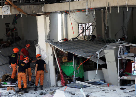 Rescuers are seen at a collapsed four-storey building following an earthquake in Porac town, Pampanga province, Philippines, April 23, 2019. REUTERS/Eloisa Lopez