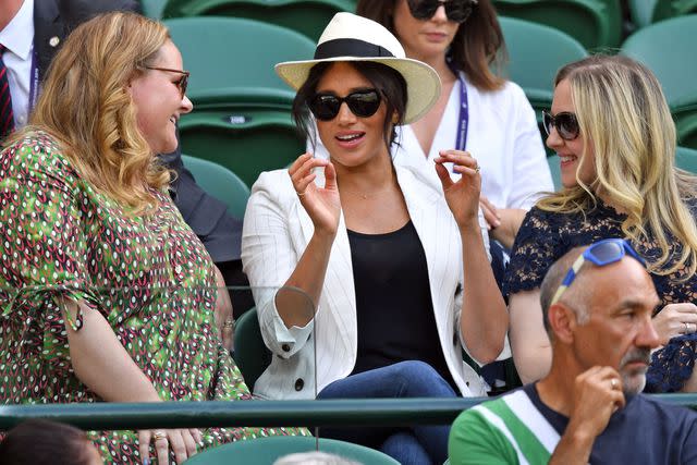 <p>GLYN KIRK/AFP via Getty </p> Meghan Markle wears a hat at Wimbledon 2019