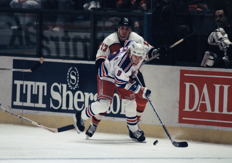 FILE - In this Jan. 7, 1991 file photo, New York Rangers Bernie Nicholls (9) moves the puck while Philadelphia Flyers Craig Berube (17) skates in pursuit during first period action at Madison Square Garden in New York. The Rangers defeated the Flyers 3-2.. The NHL hasn't had best-of-five playoff series since 1986. That's changing for this year with the league expanding to 24 playoff teams as part of its restart. The qualifying round will feature 16 teams facing off in best-of-five series to determine who moves on (AP Photo/Ron Frehm, File)