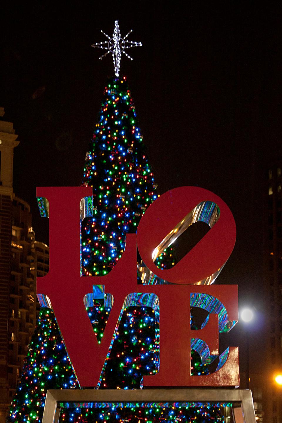 A Christmas tree is displayed behind Robert Indiana’s famous LOVE statue in Philadelphia’s  LOVE Park.