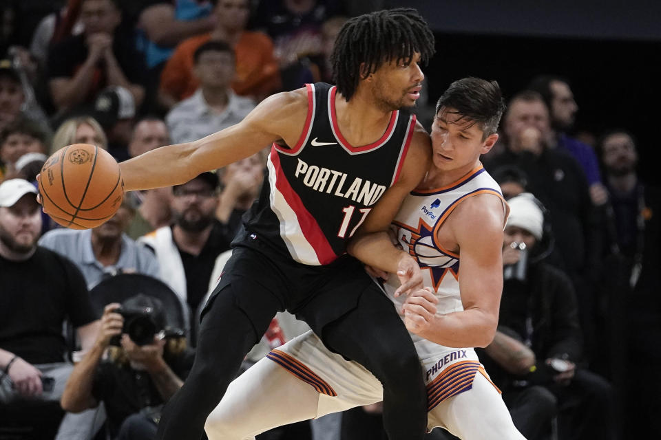 Phoenix Suns' Grayson Allen, right, guards against Portland Trail Blazers' Shaedon Sharpe (17) left, during the second half of a preseason NBA basketball game, Monday, Oct. 16, 2023, in Phoenix. Phoenix won 117-106. (AP Photo/Darryl Webb)