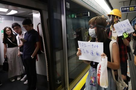 Protesters call people to join further rallies against the government at Kowloon Tong subway station in Hong Kong