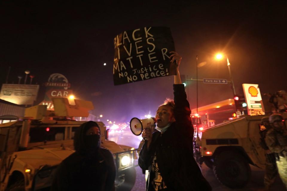 Protesters defy a curfew order in Minneapolis on Friday night.