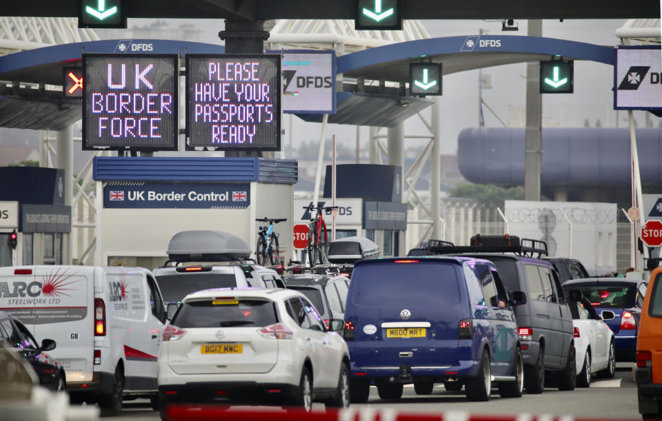 People queue in line to check-in for the cross channel ferry in Calais, France, Friday Aug.14, 2020. British holiday makers in France were mulling whether to return home early Friday to avoid having to self-isolate for 14 days following the U.K. government's decision to reimpose quarantine restrictions on France amid a recent pick-up in coronavirus infections. (AP Photo/Olivier Matthys)