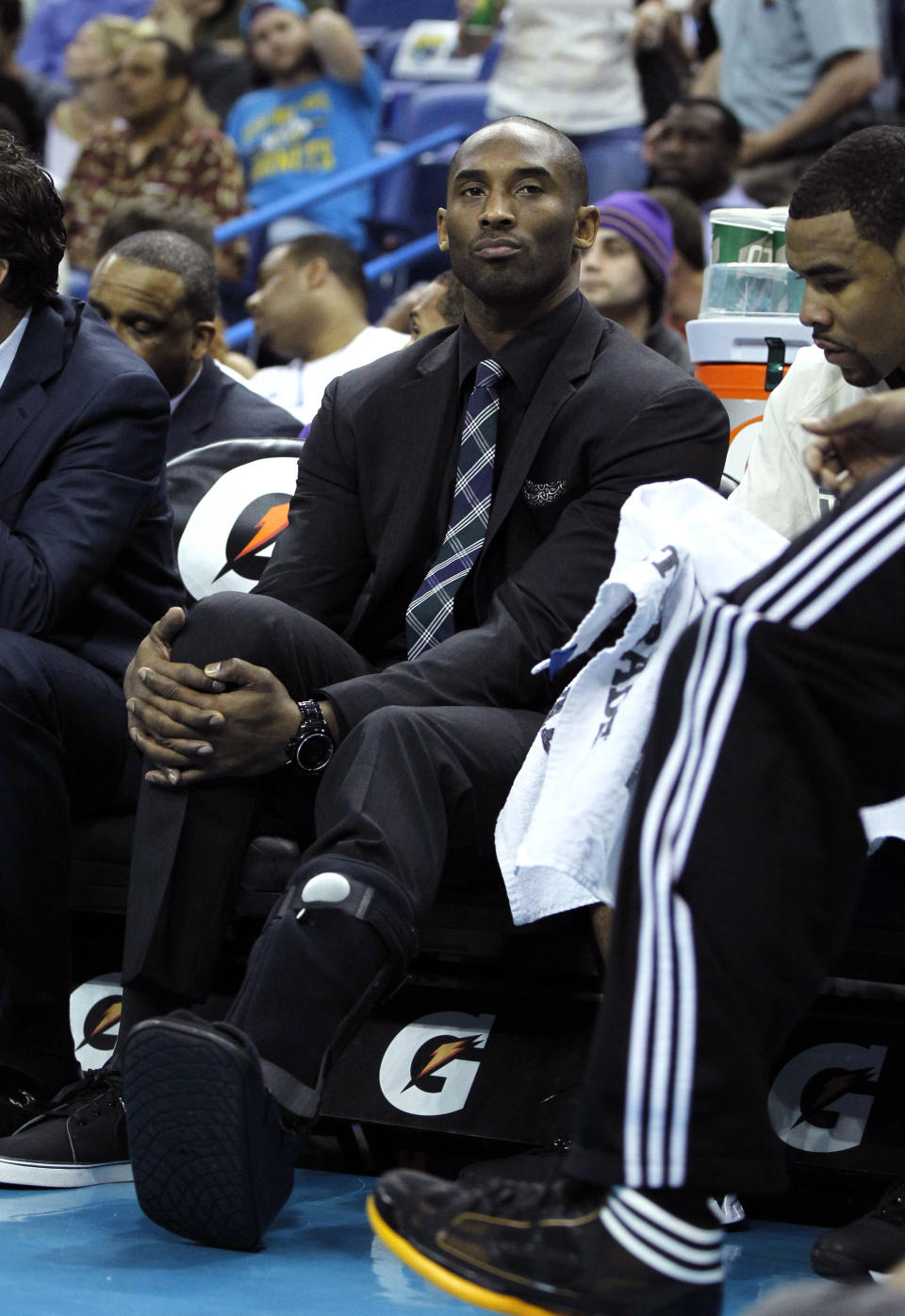 Los Angeles Lakers shooting guard Kobe Bryant watches from the bench with a cast on his foot in the first half of an NBA basketball game against the New Orleans Hornets in New Orleans, Monday, April 9, 2012. (AP Photo/Gerald Herbert)